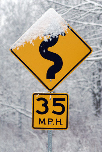 Photo of snowy curves sign